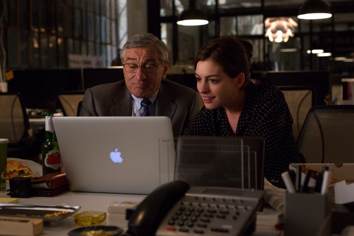 Robert De Niro i Anne Hathaway przed MacBookiem w filmie Praktykant